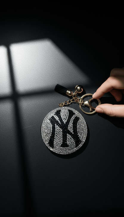 Close-up of rhinestone NY emblem and gold-tone clasp